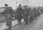 German troops after surrendering to the U.S. Third Army in WW2. The first soldier carries a white flag.